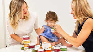 Two women feeding a baby