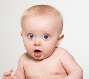 Shirtless baby with surprised look